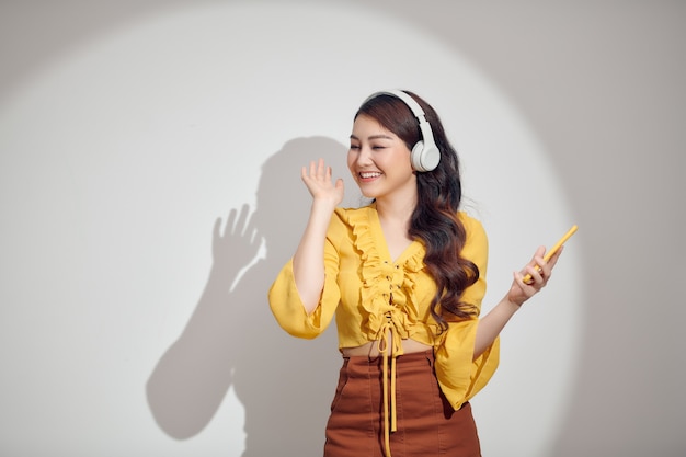 Cheerful woman écoutant de la musique avec un casque isolé