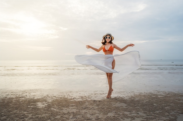 Cheerful woman in bikini profitant de la plage de la mer avec la lumière du soleil