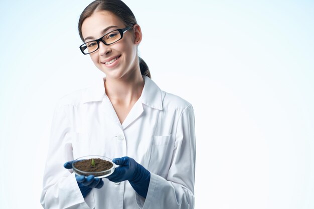 Cheerful woman in white coat étudiant science biotechnologie plantes