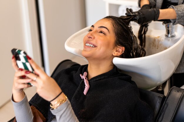 Photo cheerful woman laver les cheveux dans l'évier