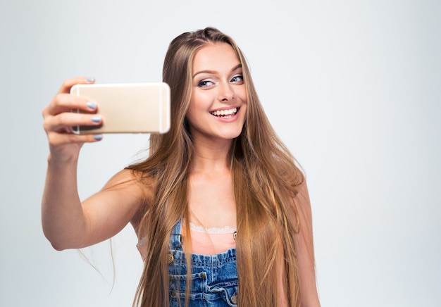 Cheerful woman making selfie photo sur smartphone