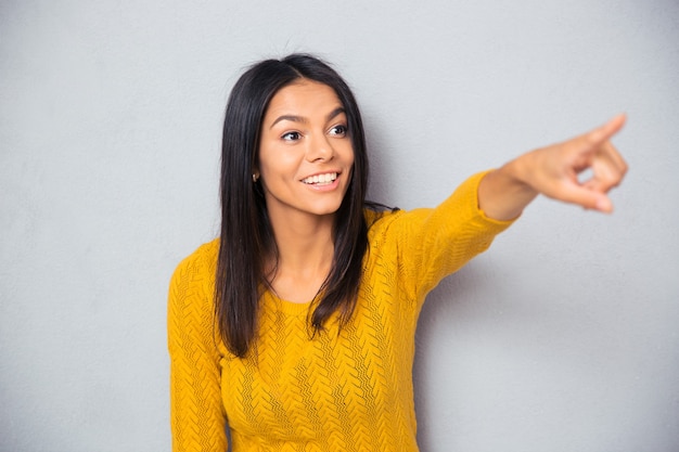 Cheerful woman montrant le doigt loin