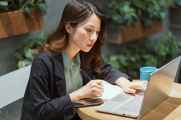 Cheerful young businesswoman travaillant au café