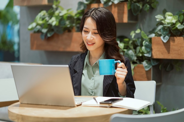 Cheerful young businesswoman travaillant au café