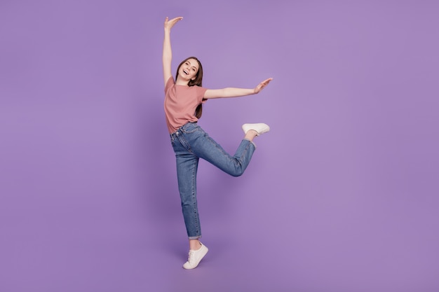 Cheerful young girl dancing isolé sur fond violet