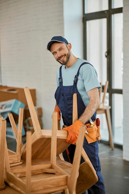 Cheerful young man repairing chair in cafe