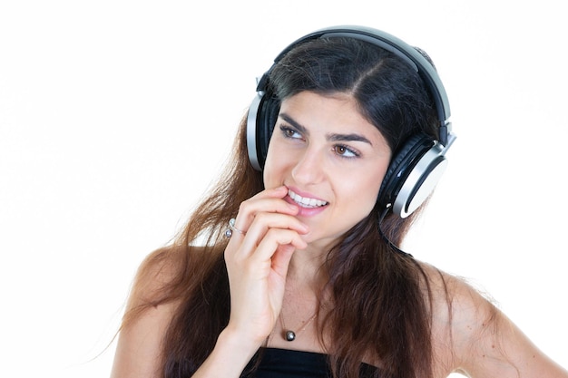 Cheerful young woman smiling doigt sur les lèvres écouter de la musique chanson au casque