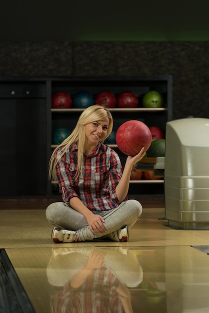 Cheerful Young Women Holding Bowling Ball