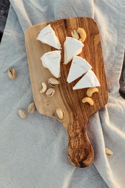 Photo cheese et noix servis sur une planche en bois pour le vin