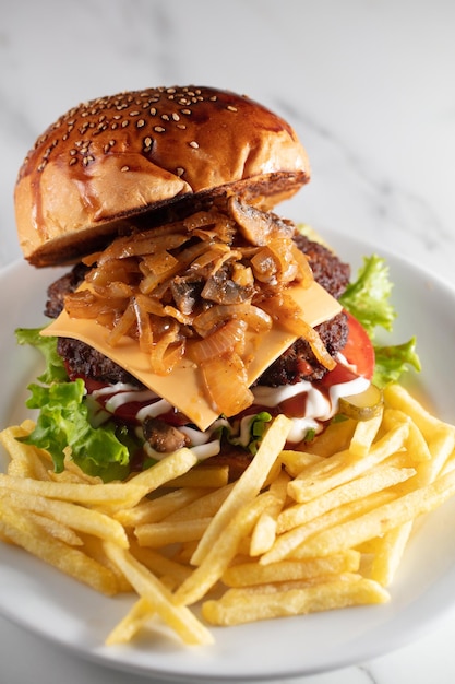 Photo cheeseburger et frites sur assiette servies au restaurant