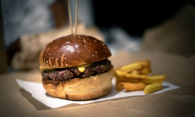 Cheeseburger et frites debout sur papier