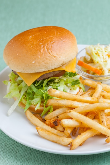 Cheeseburger avec frites et salade sur plaque