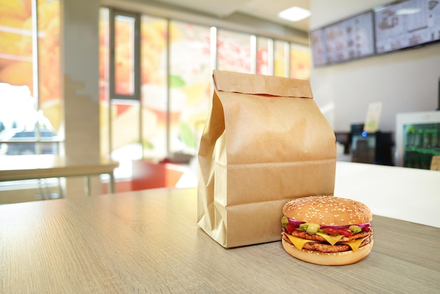 Cheeseburger et sac en papier artisanal sur le comptoir en bois du café