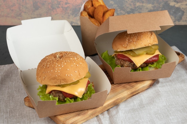 Photo cheeseburgers dans un emballage en papier pour une livraison