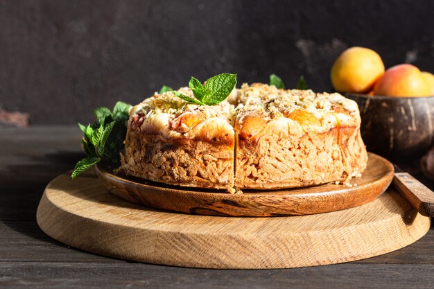 Cheesecake avec abricot et crumble, abricots frais et menthe.