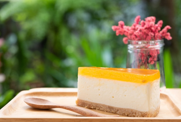 Cheesecake aux fruits de la passion, servi sur bois et table en bois avec fleur séchée