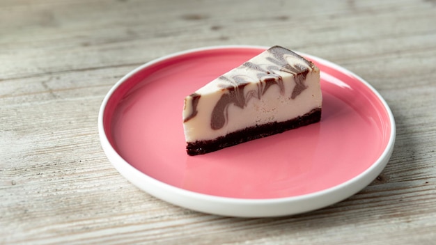 cheesecake surgelé au chocolat mélangé sur une plaque rose sur une table en bois