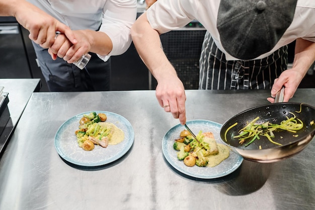 Chef ajoutant des épices sur un plat prêt