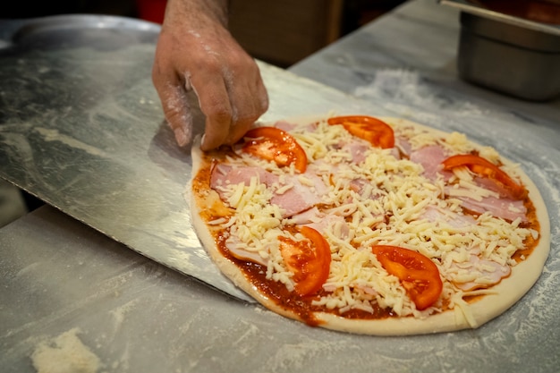 Chef à angle élevé préparant de délicieuses pizzas