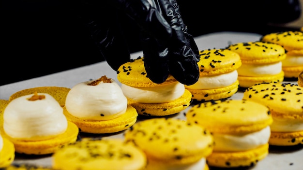 Le chef assemble des macarons jaunes, gros plan.