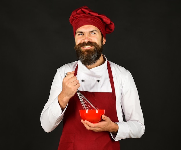 Chef avec assiette rouge et ustensile à fouetter Boulangerie et cuisine