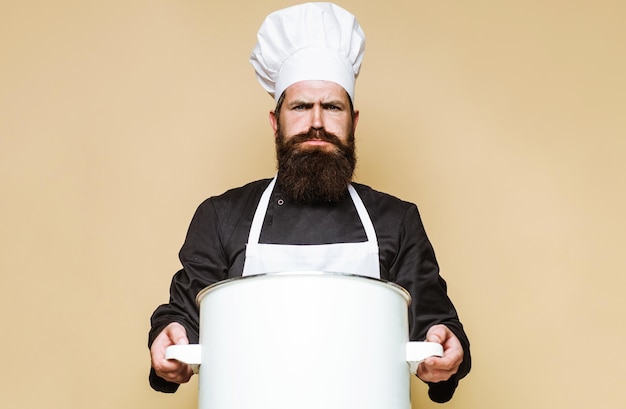 Chef barbu en uniforme avec grande casserole ou marmite ustensiles de cuisine ustensiles de cuisine préparation des aliments