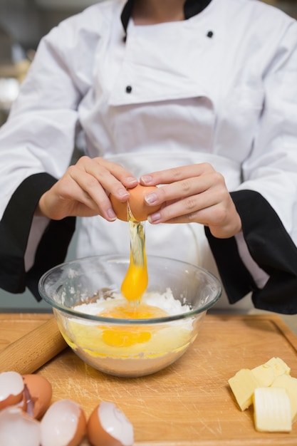 Chef casser les oeufs dans la farine