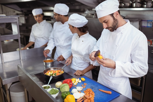 Chef contrôle de la nourriture de la cuillère dans la cuisine au restaurant