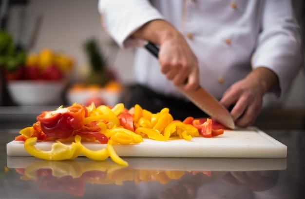 Chef coupant des légumes frais et délicieux pour la cuisson ou la salade