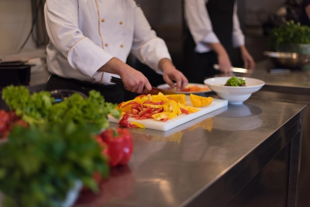 Chef coupant des légumes frais et délicieux pour la cuisson ou la salade