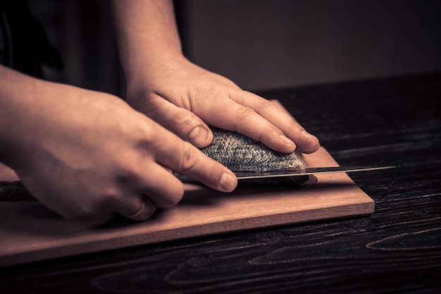 Chef coupant le poisson sur une planche