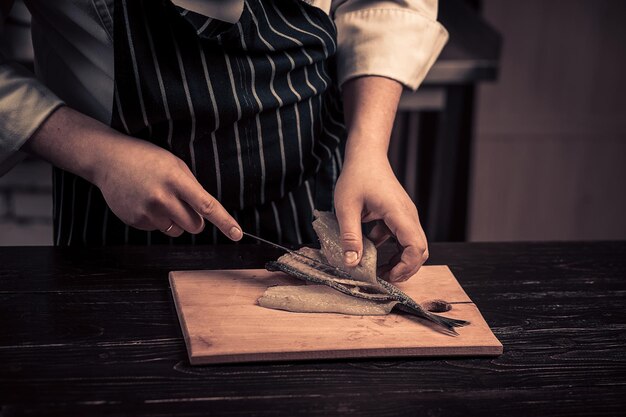 Chef coupant le poisson sur une planche