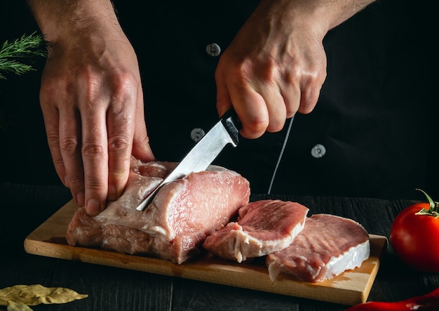 Chef Coupant La Viande Avec Un Couteau Sur La Cuisine Faisant Cuire Des Aliments Légumes Et épices Sur La Table De La Cuisine