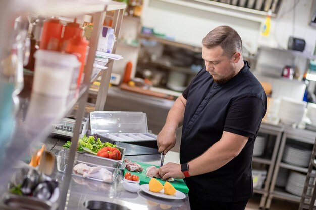 Le chef coupe la carcasse de poulet et la prépare pour la marinade