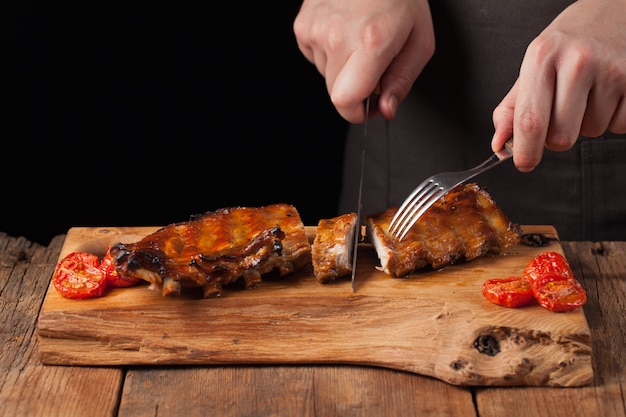 Le chef coupe un couteau prêt à manger des côtes de porc.