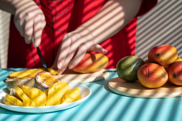 chef coupe fruits mains féminines coupe mangue et fruit de la passion petit-déjeuner aux fruits