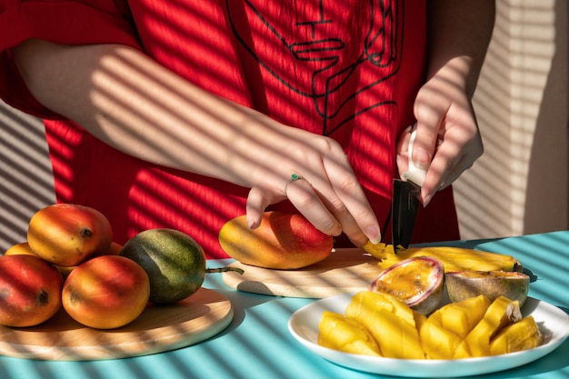 chef coupe fruits mains féminines coupe mangue et fruit de la passion petit-déjeuner aux fruits