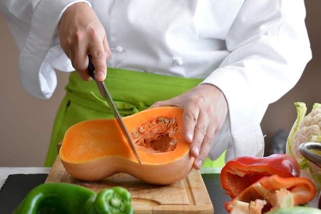 Chef coupe les légumes à la table pour la cuisson