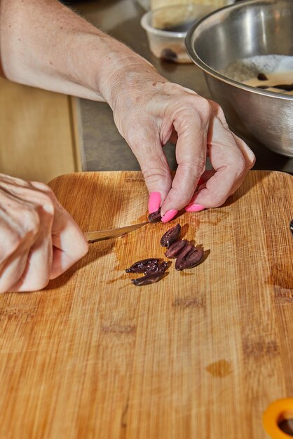 Le chef coupe des olives pour les ajouter au plat.