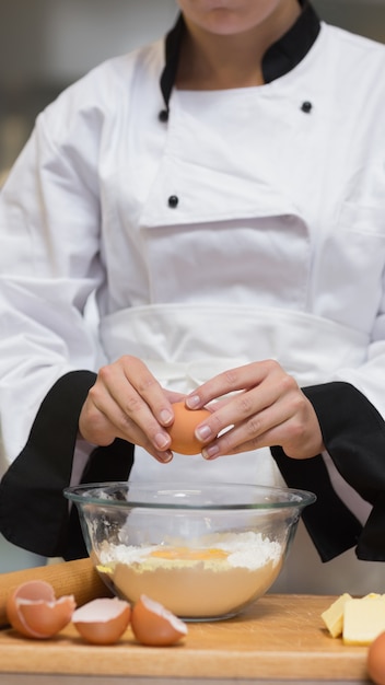 Chef de craquage oeuf dans un bol de farine