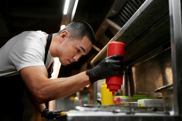 Chef cuisinant dans la cuisine en portant une tenue professionnelle