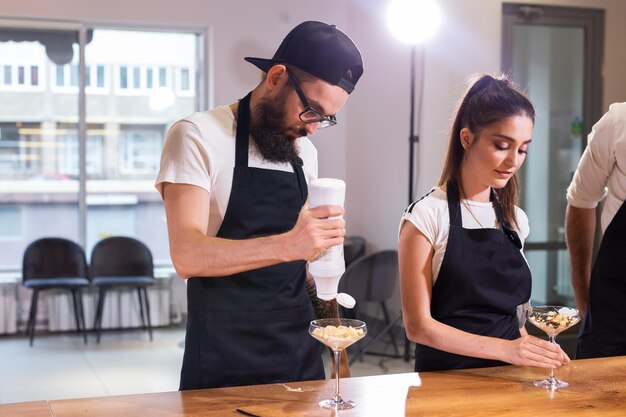 Chef cuisinant un délicieux dessert à la crème glacée à base de chocolat et de vanille dans un bol en verre