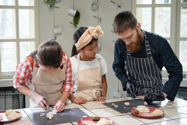 Chef cuisinant des pizzas avec des enfants