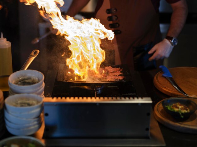 Chef cuisinant de la viande sur un barbecue lors d'une célébration