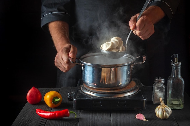 Le chef cuisine des boulettes de viande dans une casserole dans la cuisine du restaurant