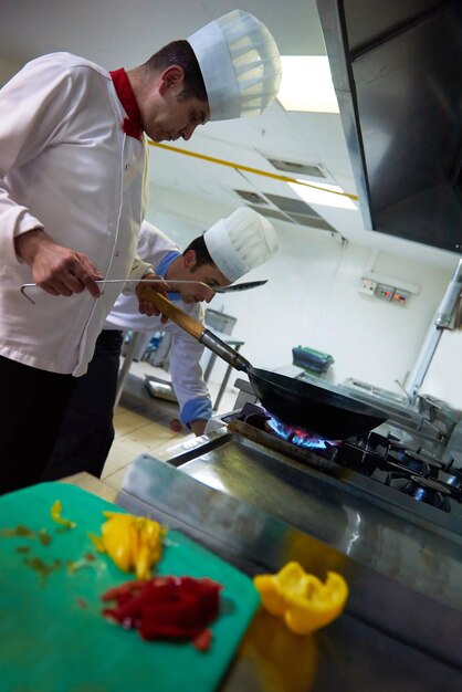 le chef de la cuisine de l'hôtel prépare des plats végétaux avec le feu