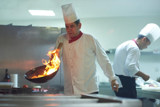 le chef de la cuisine de l'hôtel prépare des plats végétaux avec le feu