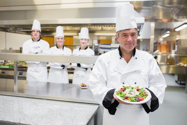 Chef de cuisine présentant une salade