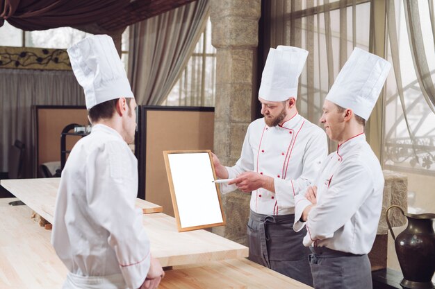 Chef de cuisine et son personnel en cuisine. interagissant dans la cuisine commerciale.