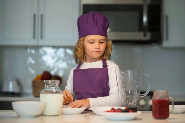 Chef cuisinier enfant s'amusant à préparer un gâteau dans la cuisine à la cuisine